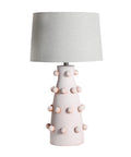 Lámpara de sobremesa con base de cerámica en color rosa y pantalla de lino beige, ideal para un toque elegante y acogedor.